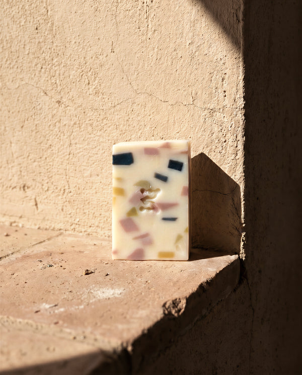 Momenti Costiera soap bar on a textured stone surface