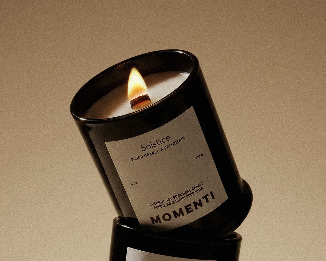 Momenti candle with a label on a beige background
