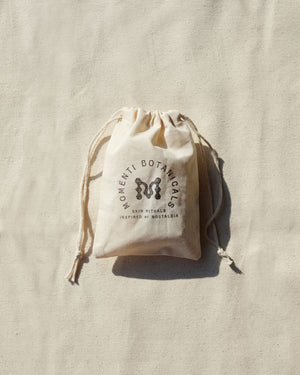 Organic Cotton Gift Bag with the Momenti Botanicals crest stamped on the front of the bag